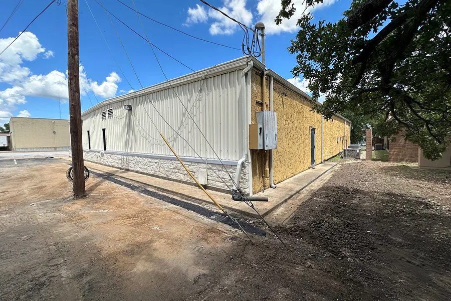 Completed drainage run backfilled alongside a commercial building