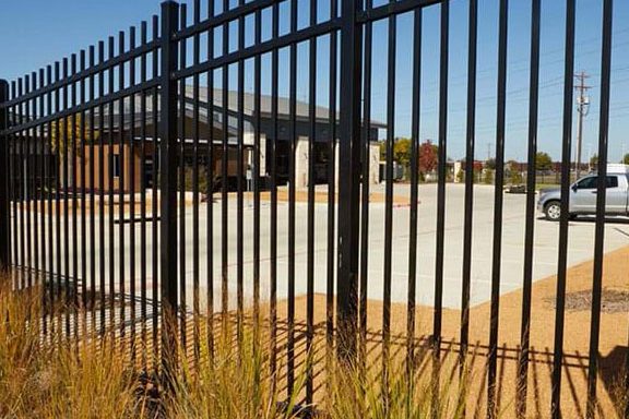 Black ornamental iron fence in front of a commercial building