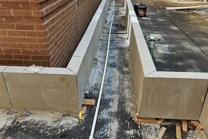 Irrigation line run along a commercial building with the crew on site