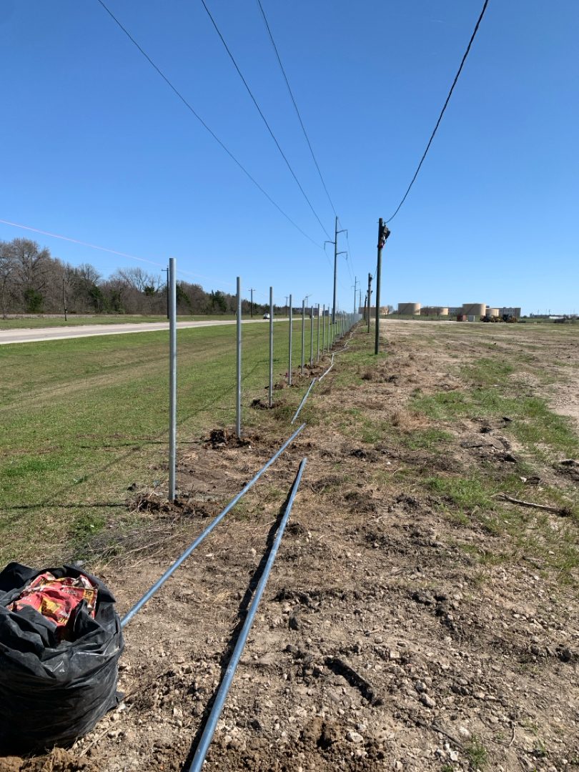 Chain link line posts set along a long commercial fence run