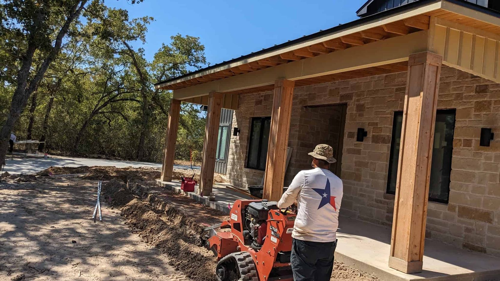 Lone Star crew member running a walk-behind trencher on a job site