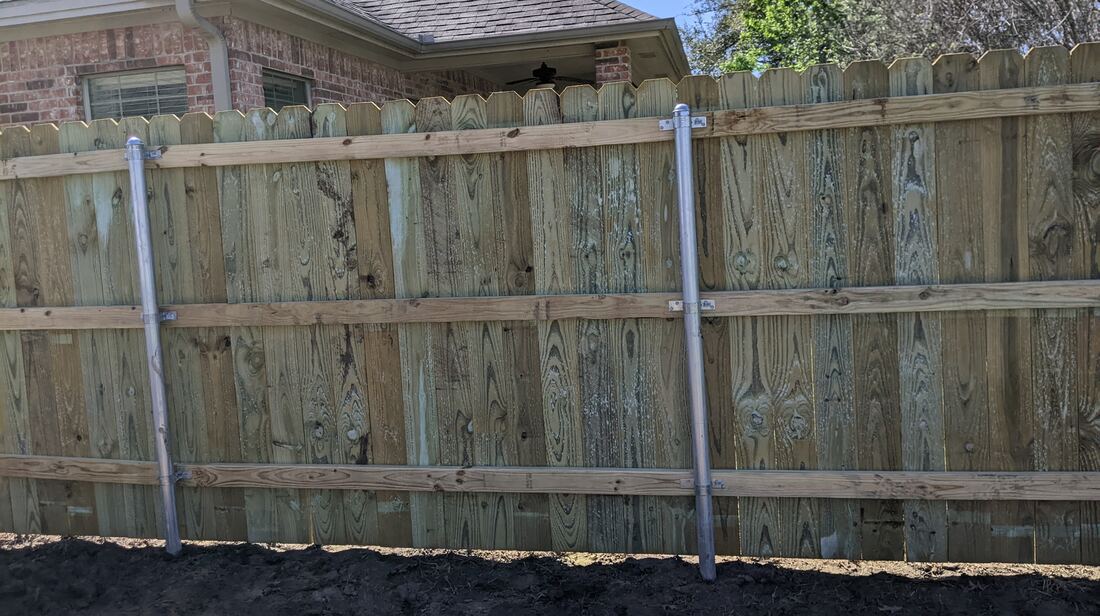 Wood fence rebuilt onto new steel posts