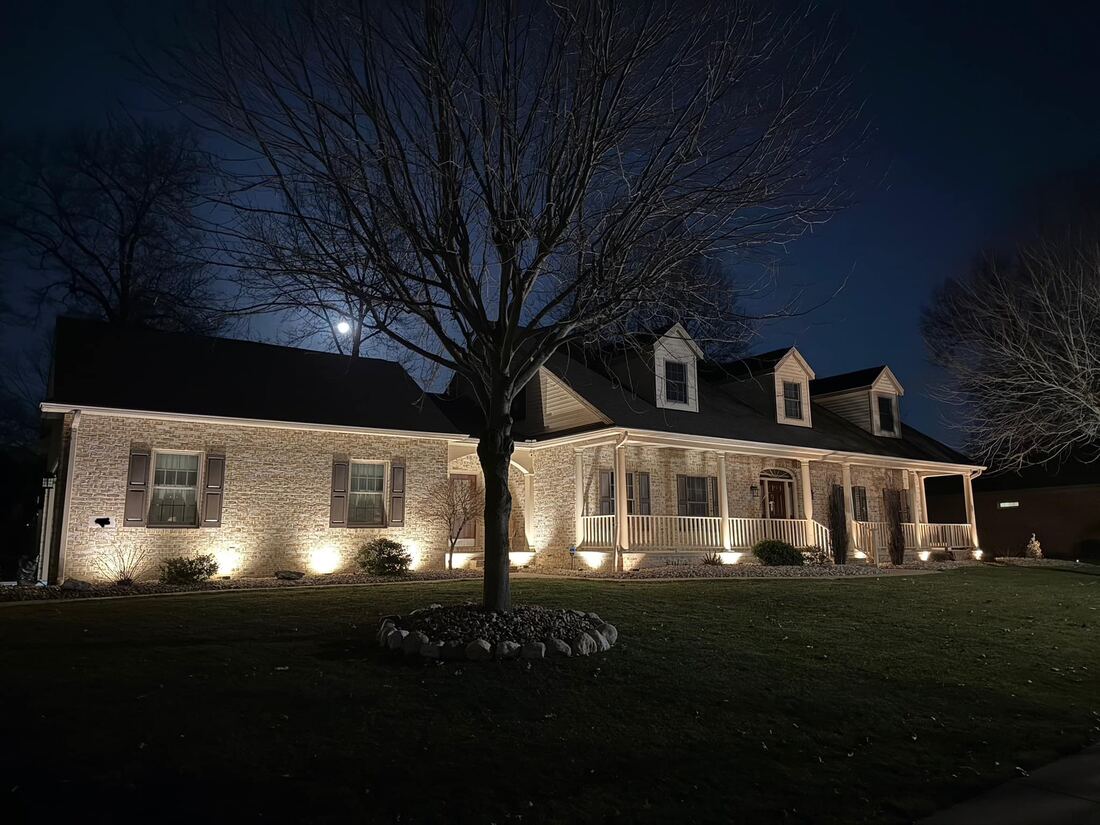 Warm light grazing the brick facade of a home after dark