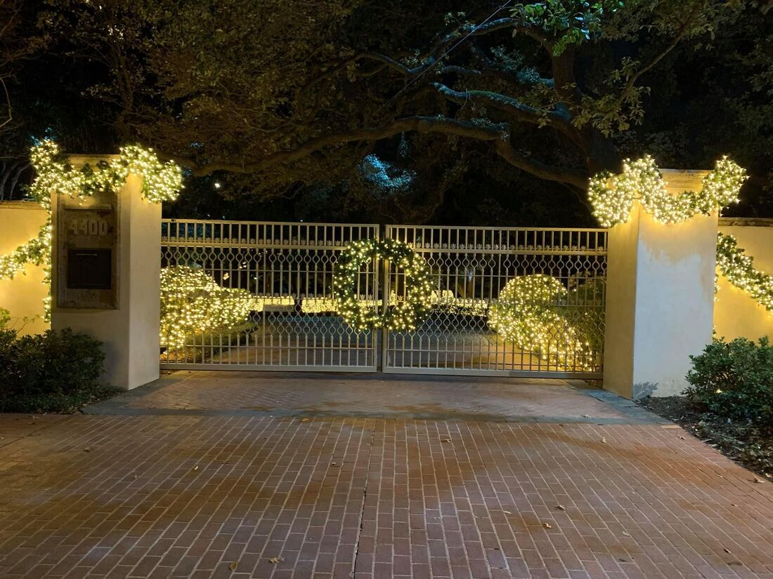 Holiday lighting run along an entry gate and fence line