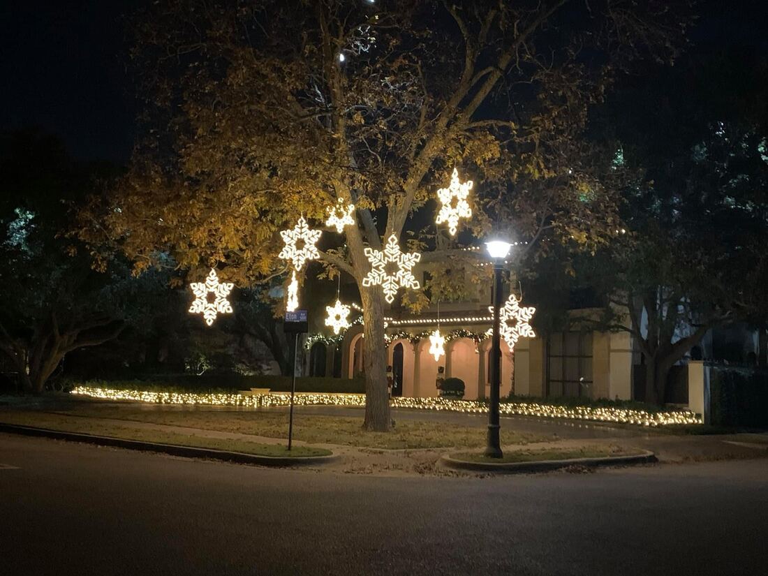 Lit snowflake decor on a Christmas lighting install